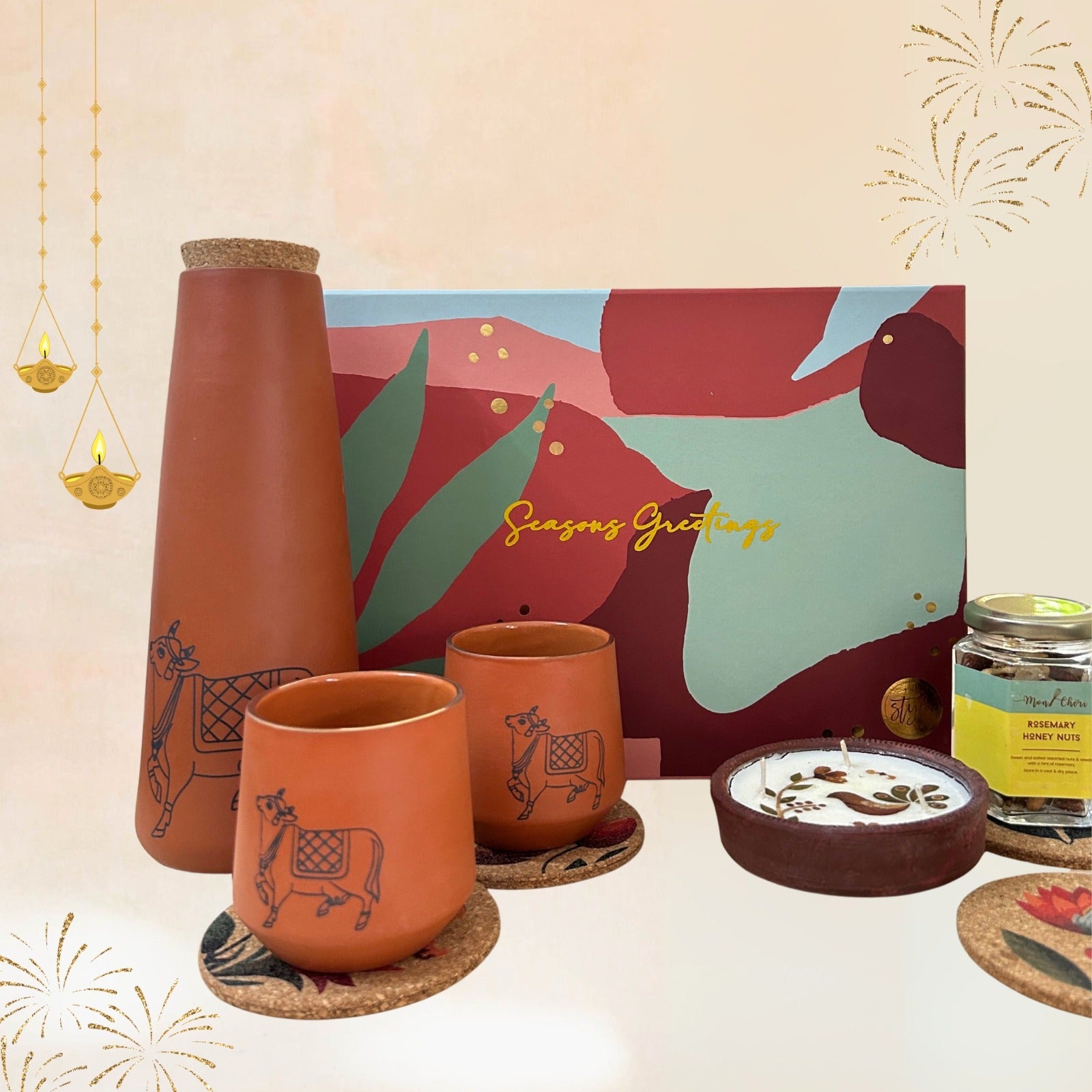 Festive gift hamper with Flora cork coasters, rosemary honey nuts, Kapila bottle and glass terracotta set, and a three-wick floral terracotta diya