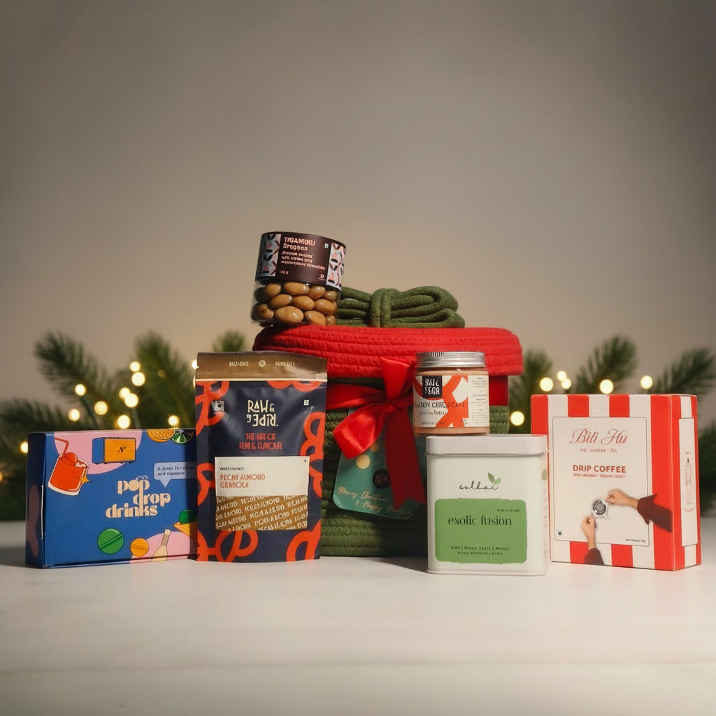 Assorted gift items including coffee, snacks, and a basket with a red bow. Christmas gourmet hamper. 