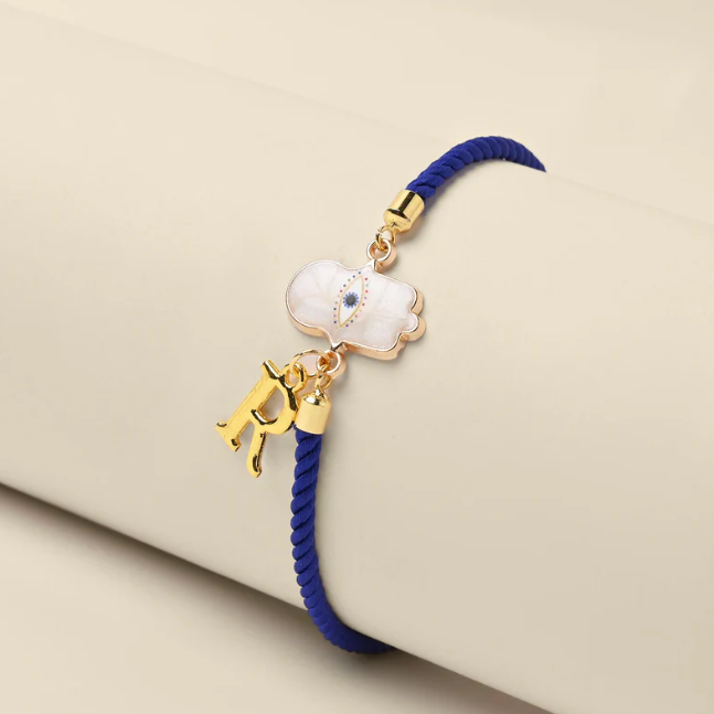 Minimalist Hamsa Initial Rakhi design combining traditional symbolism with modern style.